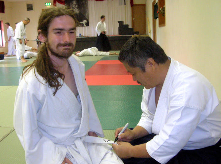 Gaku Homma writes names on people's keikogi